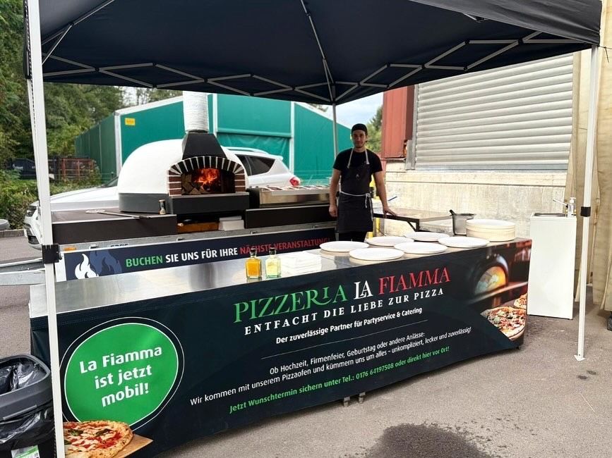 Pizzastand mit Mann, Außenkulisse, Pizzaofen und Banner.