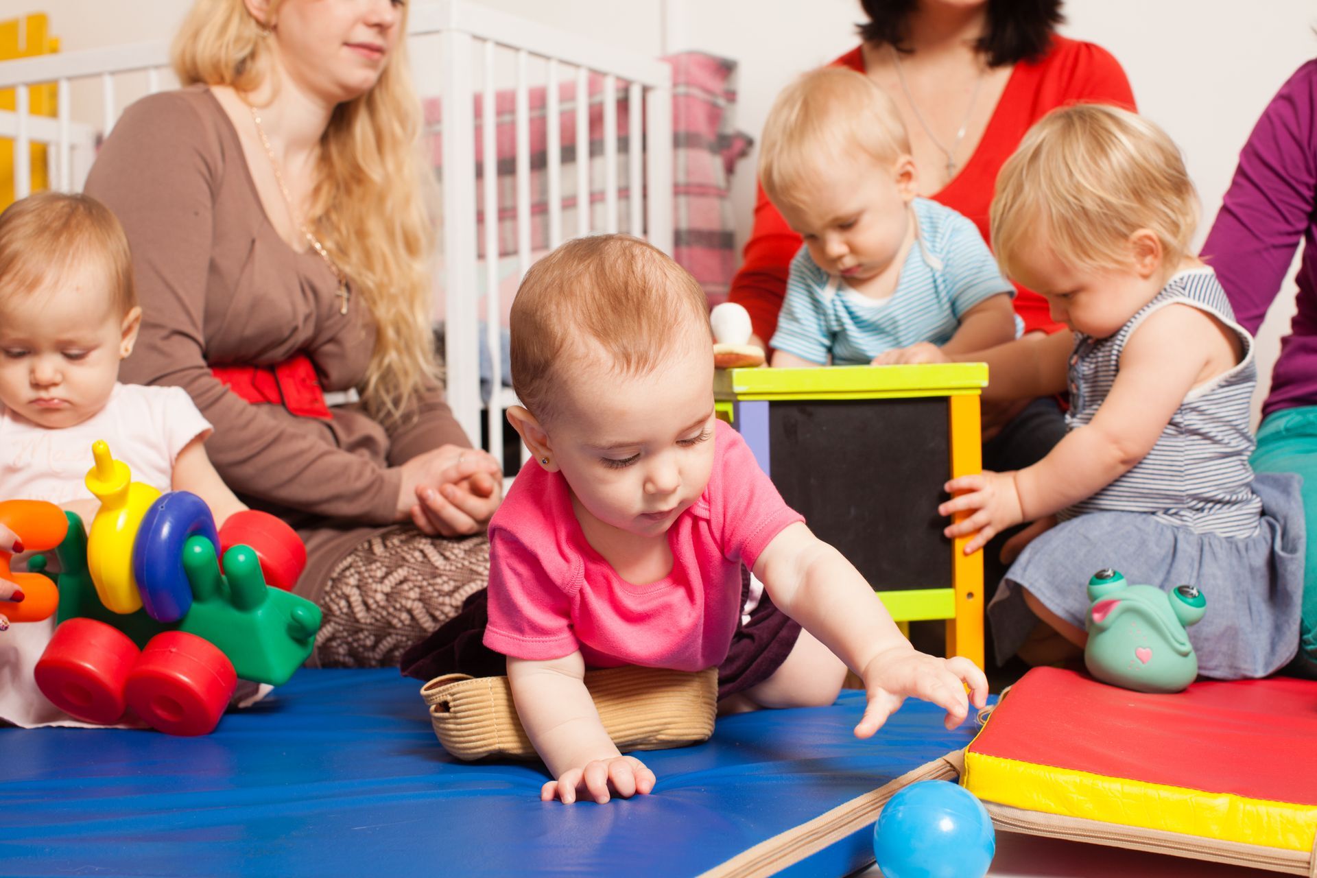 Des enfants en train de jouer avec trois femmes.