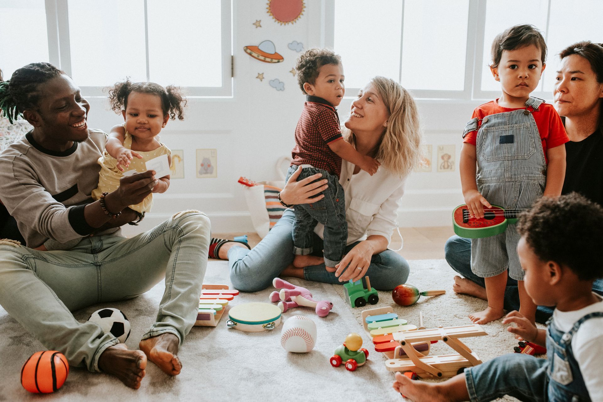 Des adultes assis par terre avec des enfants.