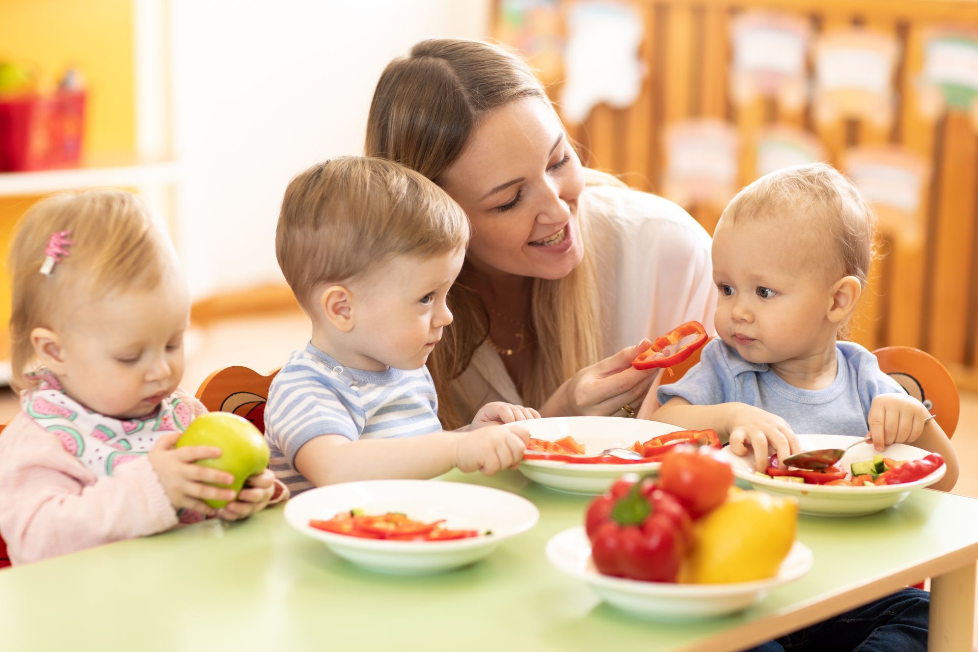Une femme donnant à manger à des enfants.