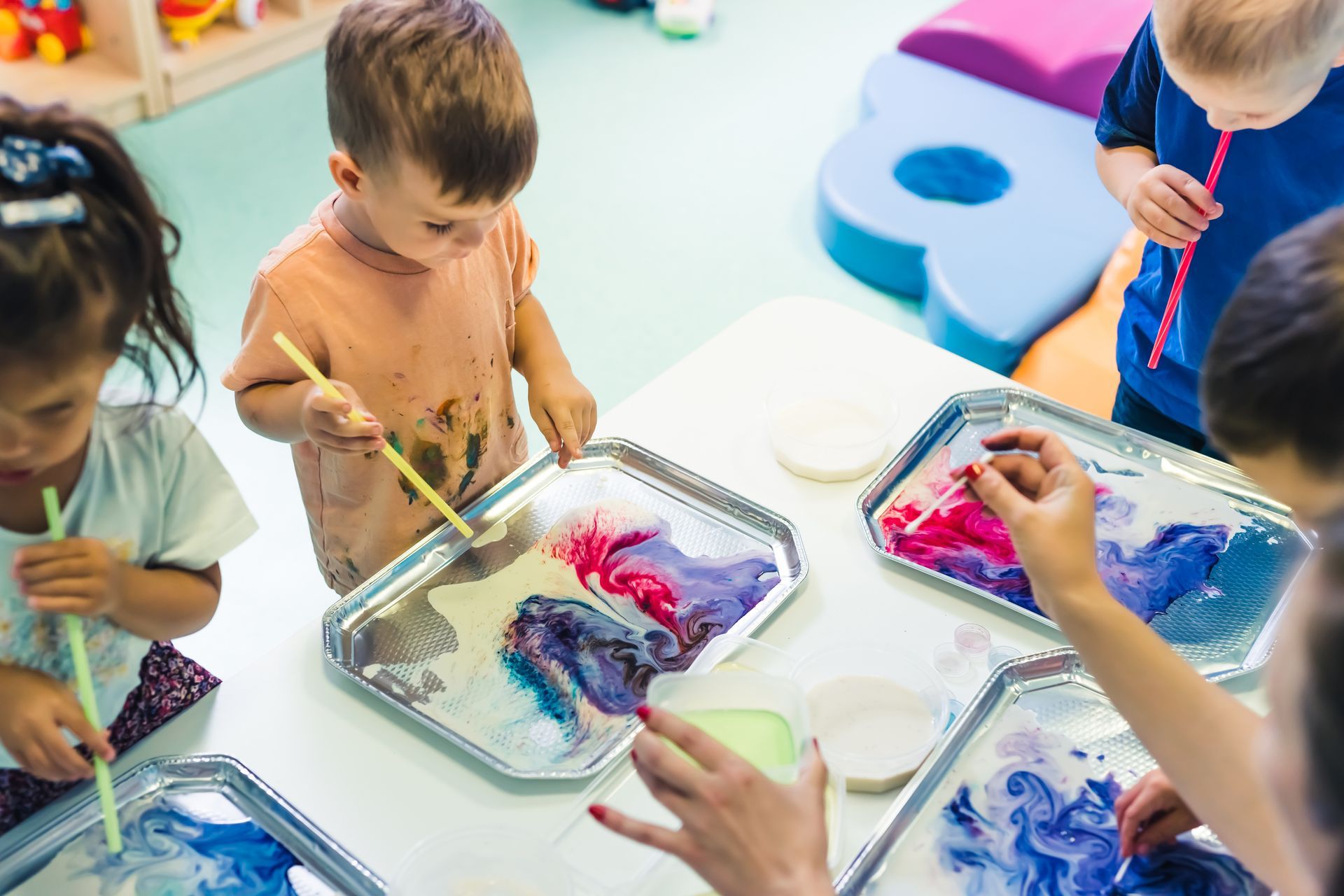 Des enfants faisant une activité avec de la peinture.