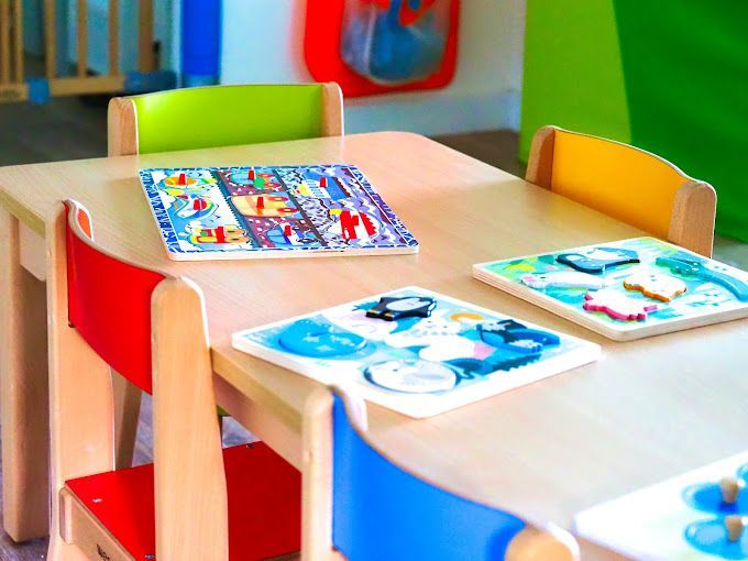 Une table en bois pour les enfants avec des livres dessus.