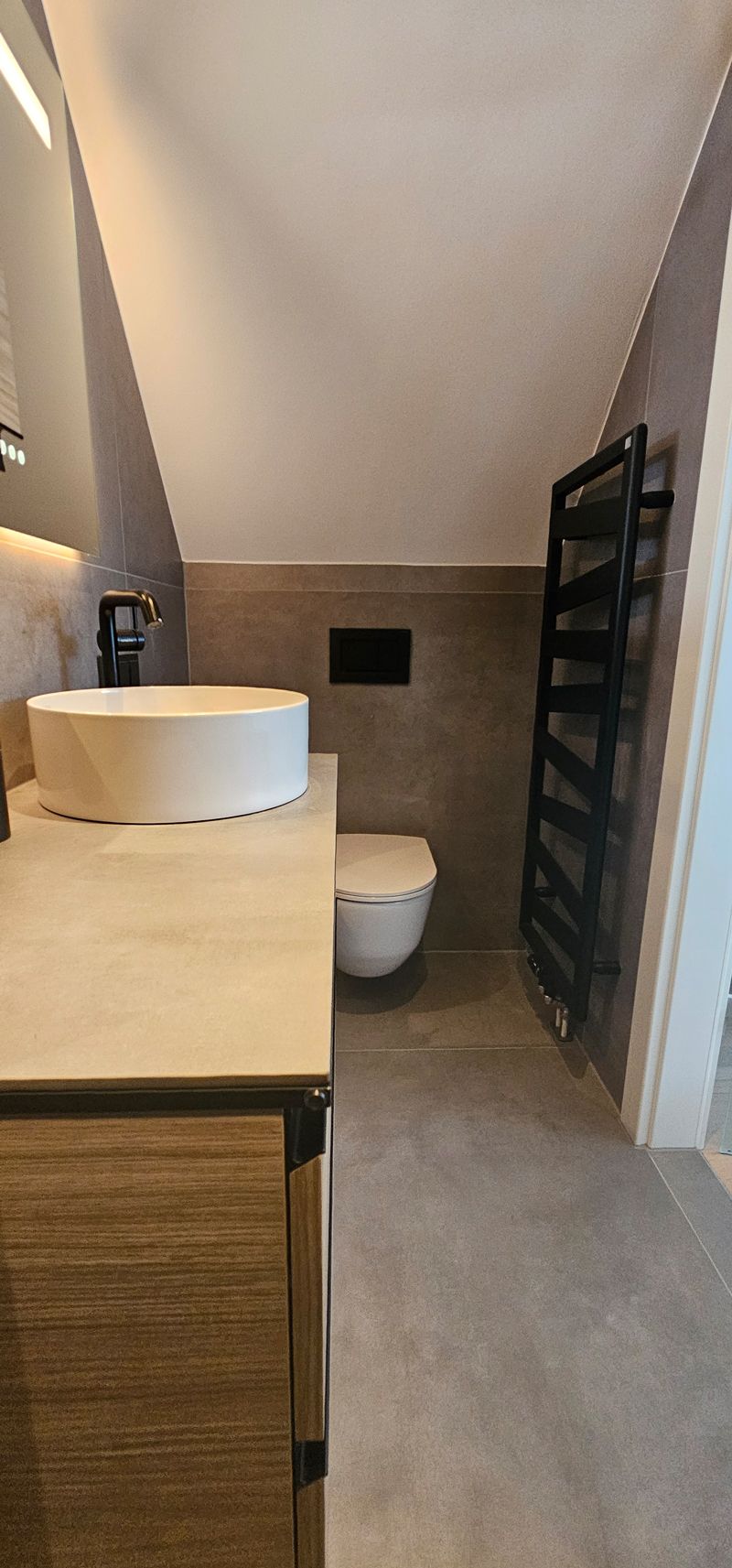 Eine Toilette in einem Badezimmer mit einer tropischen Tapete an der Wand.