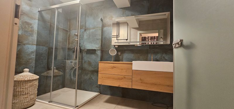 Eine Toilette in einem Badezimmer mit einer tropischen Tapete an der Wand.