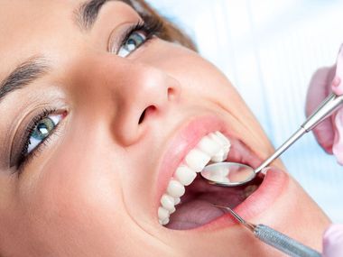 Una mujer está siendo examinada por un dentista.