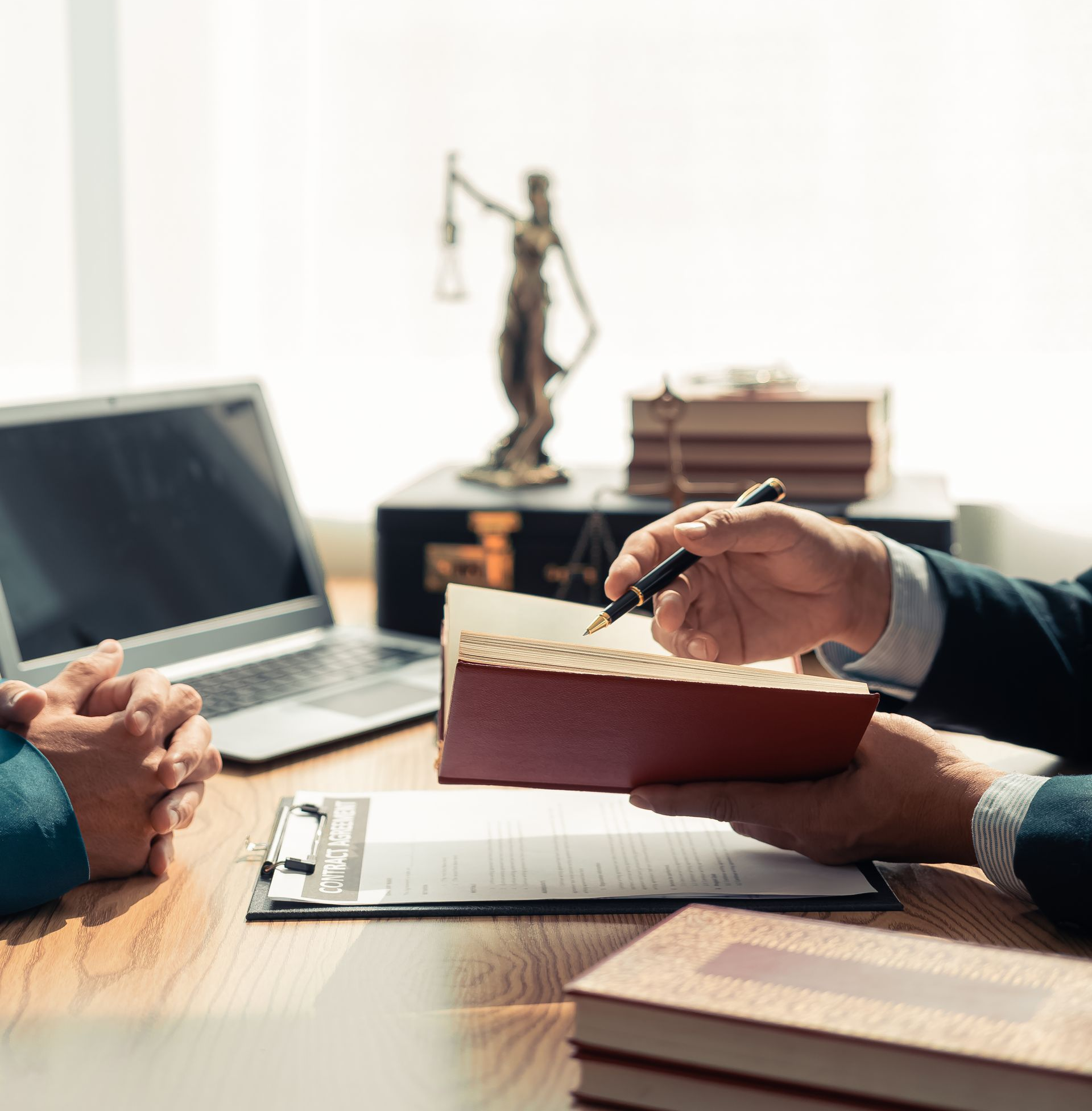 Un avocat à son bureau. Il montre un document à un client.