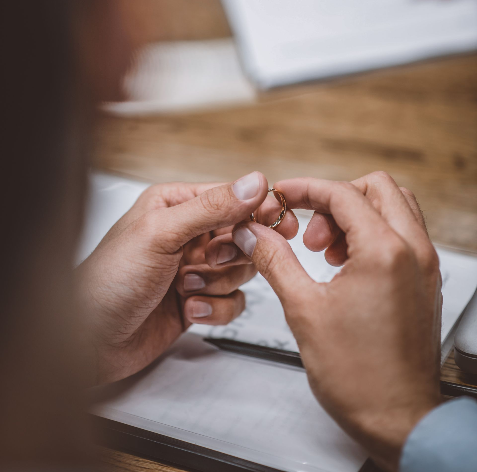 Une personne tient une alliance dans ses mains.