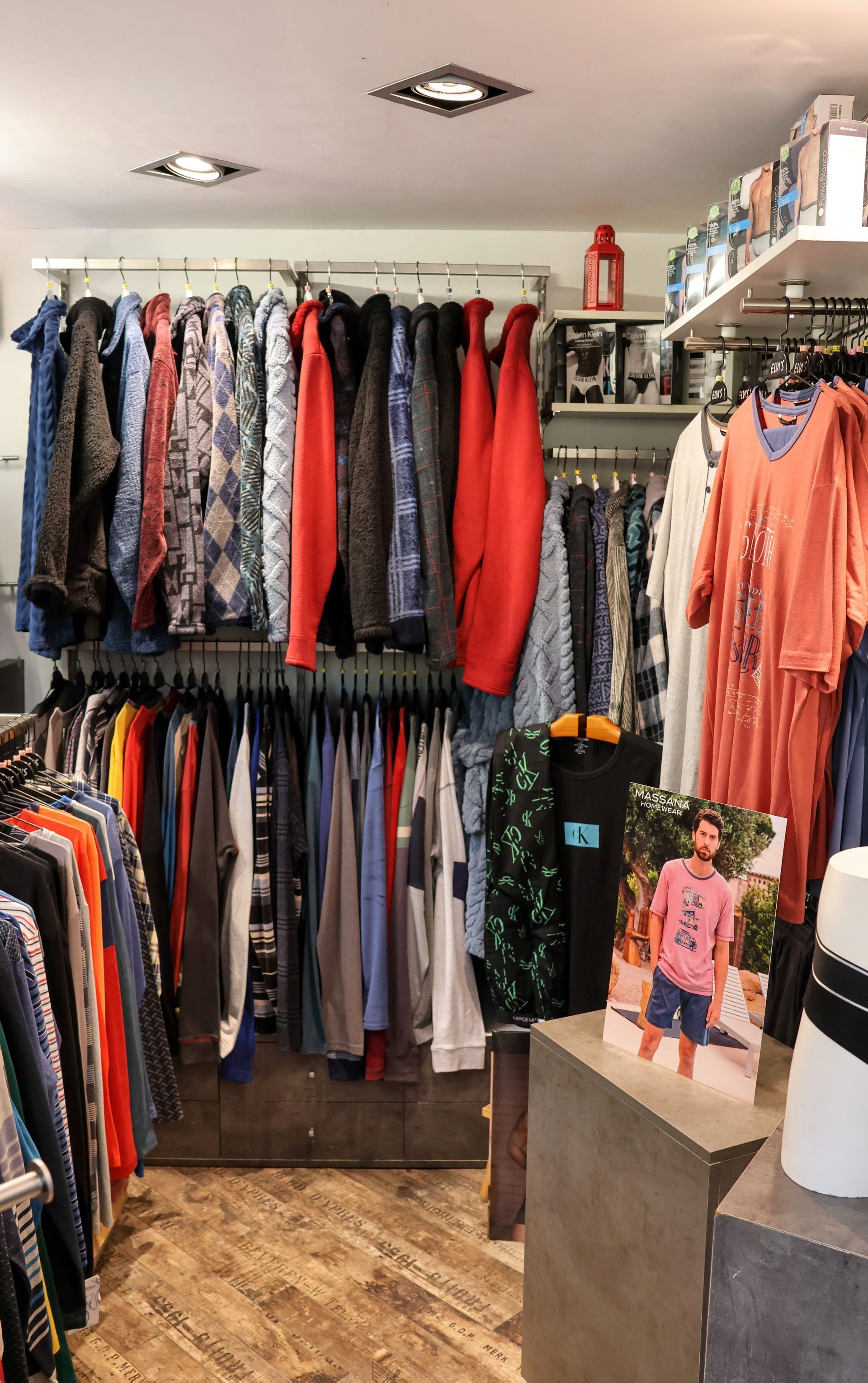 Una tienda llena de mucha ropa y un maniquí.