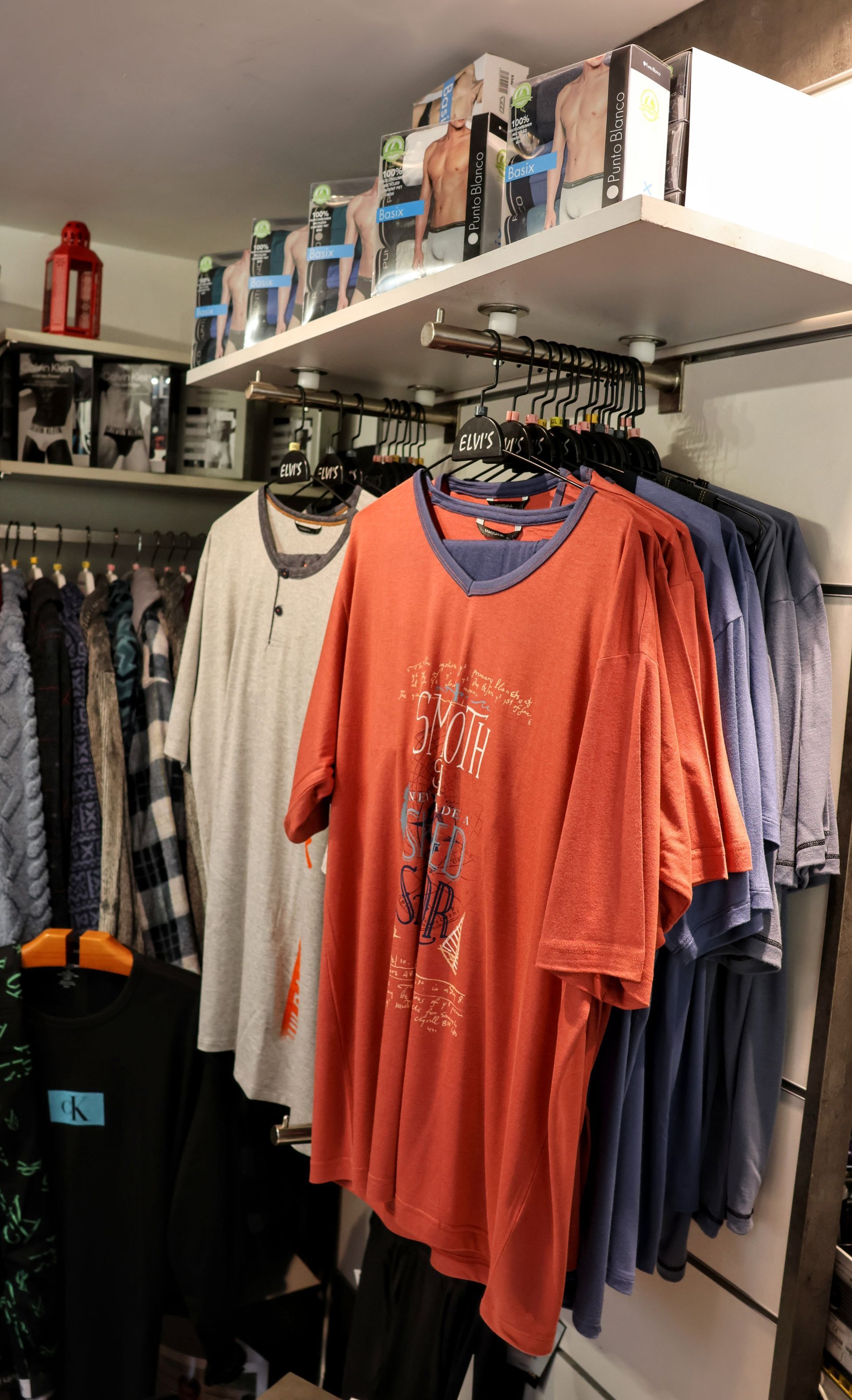 Un montón de camisas están colgadas en un perchero en una tienda.