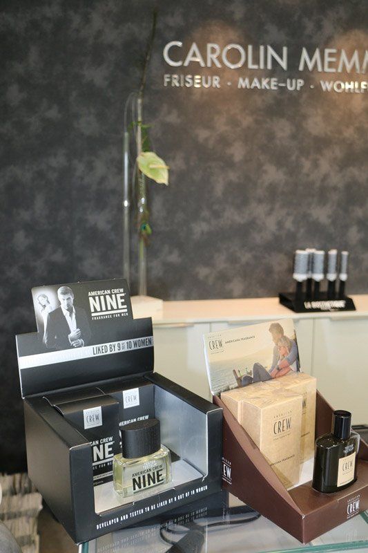 Präsentation von Haar- und Schönheitsprodukten im Salon „CAROLIN MEMMERT“; schwarze, silberne und braune Boxen mit der Marke „NINE“.