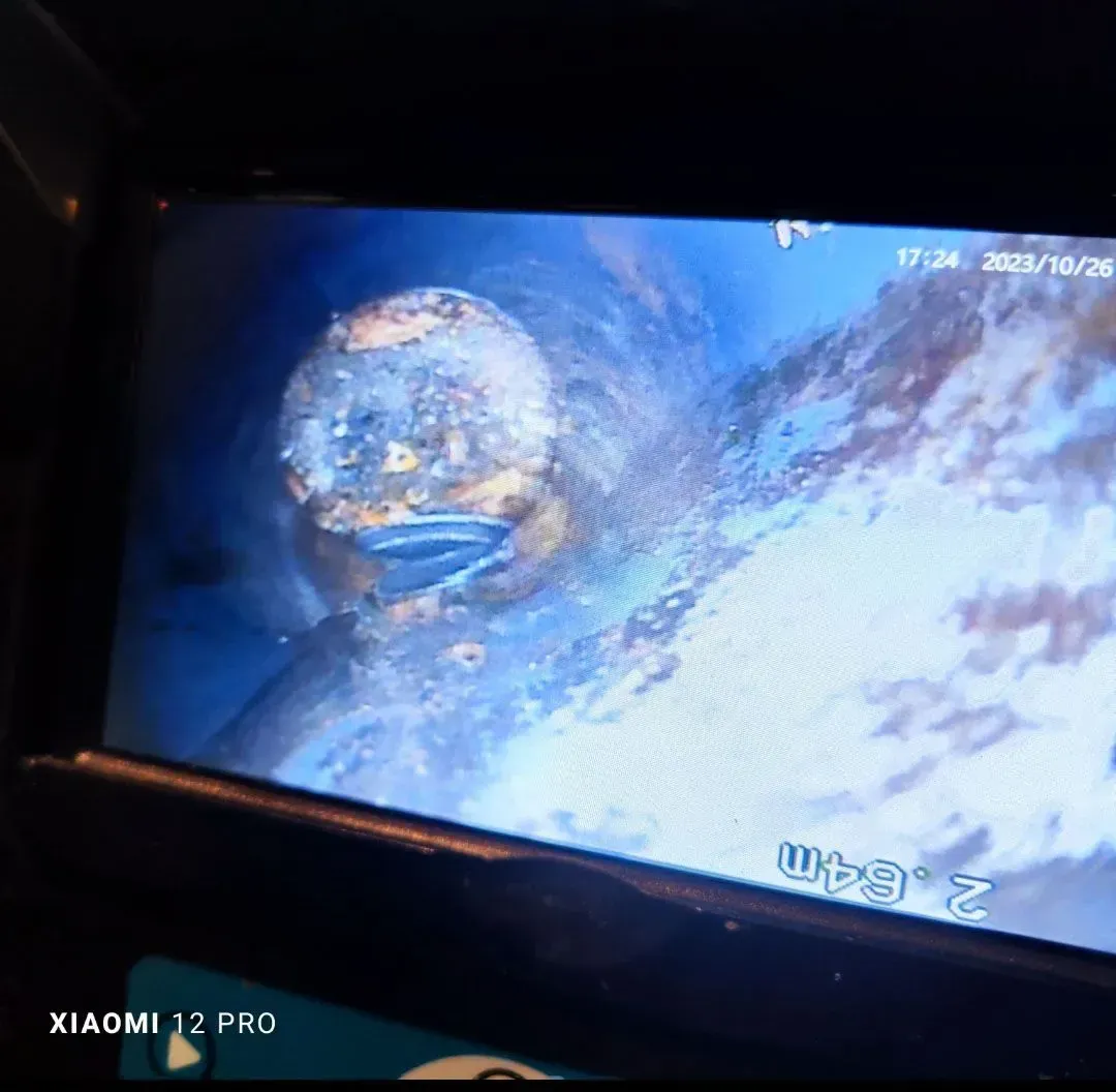 La Tierra vista desde el espacio con nubes azules, mostrada en una pantalla de televisión en ángulo.