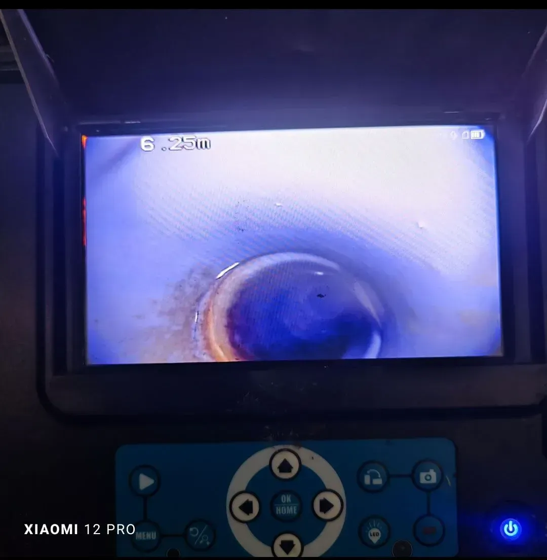 Pantalla que muestra un primer plano del interior de una tubería circular, con un panel de control azul debajo.