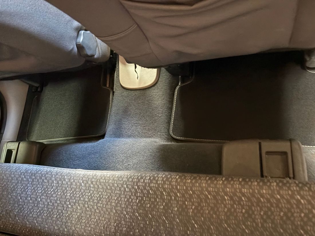 Vue intérieure du plancher arrière d'une voiture, après prestation de nettoyage.