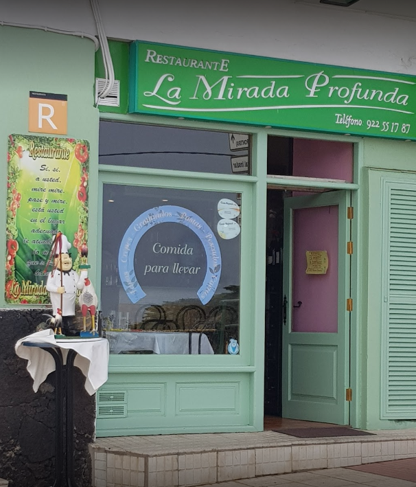 Fachada verde menta del restaurante “La Mirada Profunda”, con letrero y puerta de cristal.