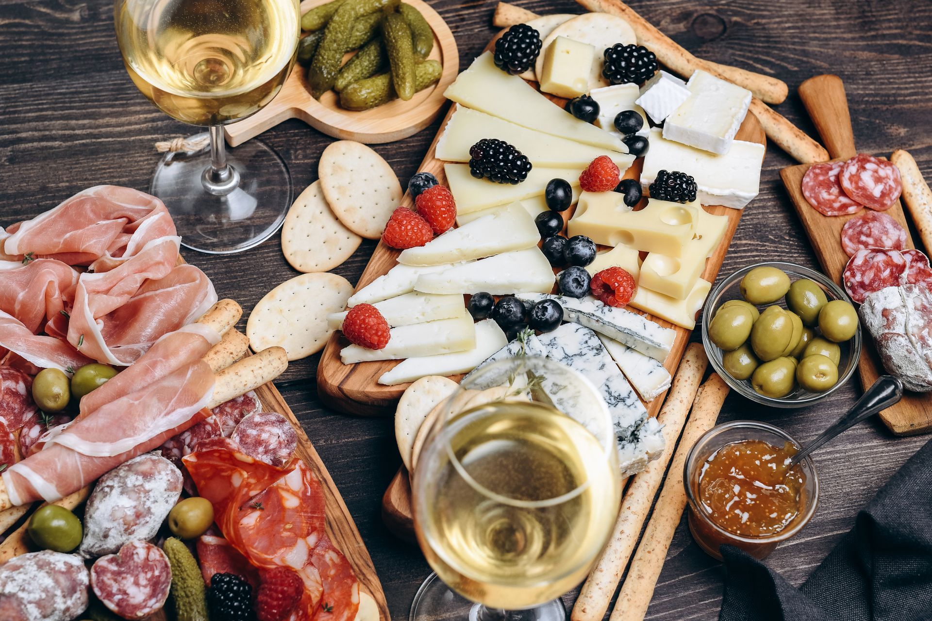 Du fromage, charcuterie, olives, fruits sur des planches pour un apéritif