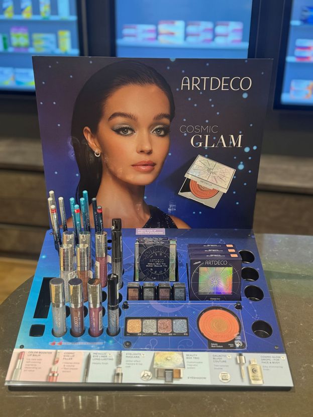 Flaschen „Wilde Lilli“-Likör auf einem dekorativen Tablett, ausgestellt in einem Ladenlokal, mit Preisschild.