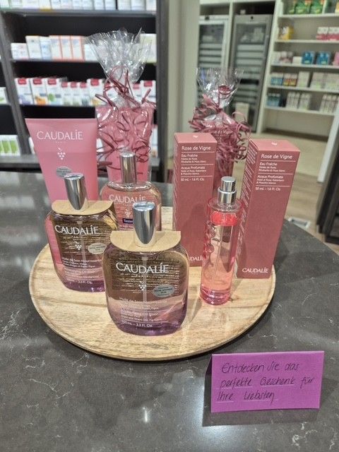 Flaschen „Wilde Lilli“-Likör auf einem dekorativen Tablett, ausgestellt in einem Ladenlokal, mit Preisschild.