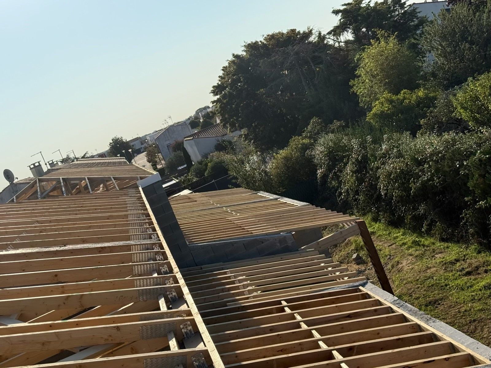Chantier de construction avec poutres apparentes à flanc de colline.