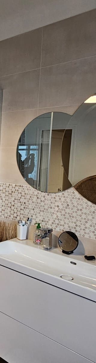 Un miroir ovale reflète une pièce