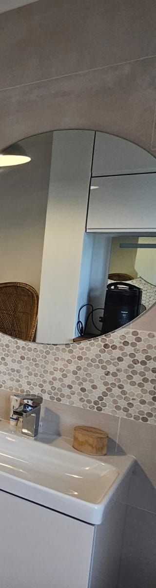 Salle de bains avec lavabo, miroir et crédence en mosaïque