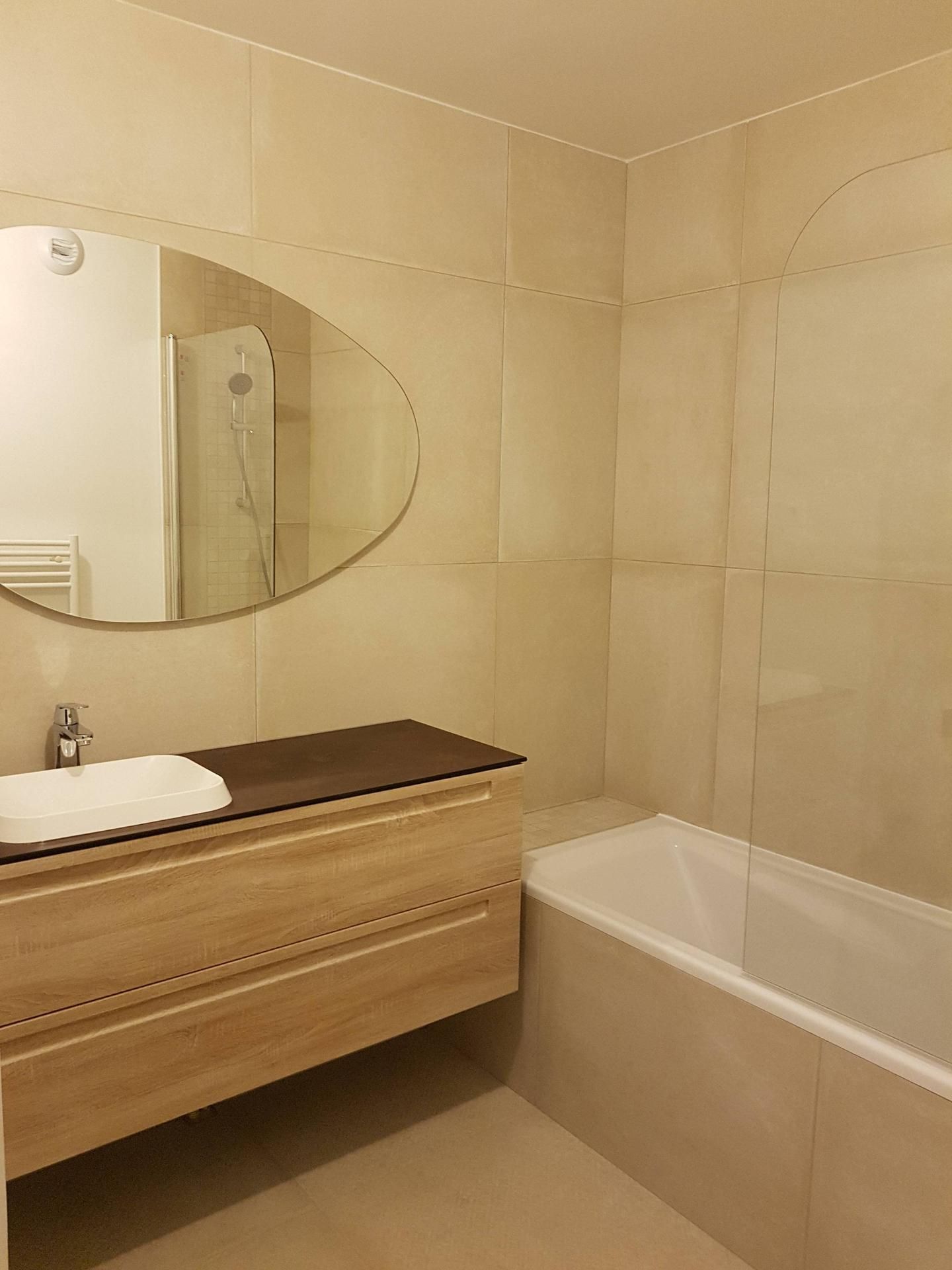 Salle de bains avec lavabo un miroir ovale au dessus