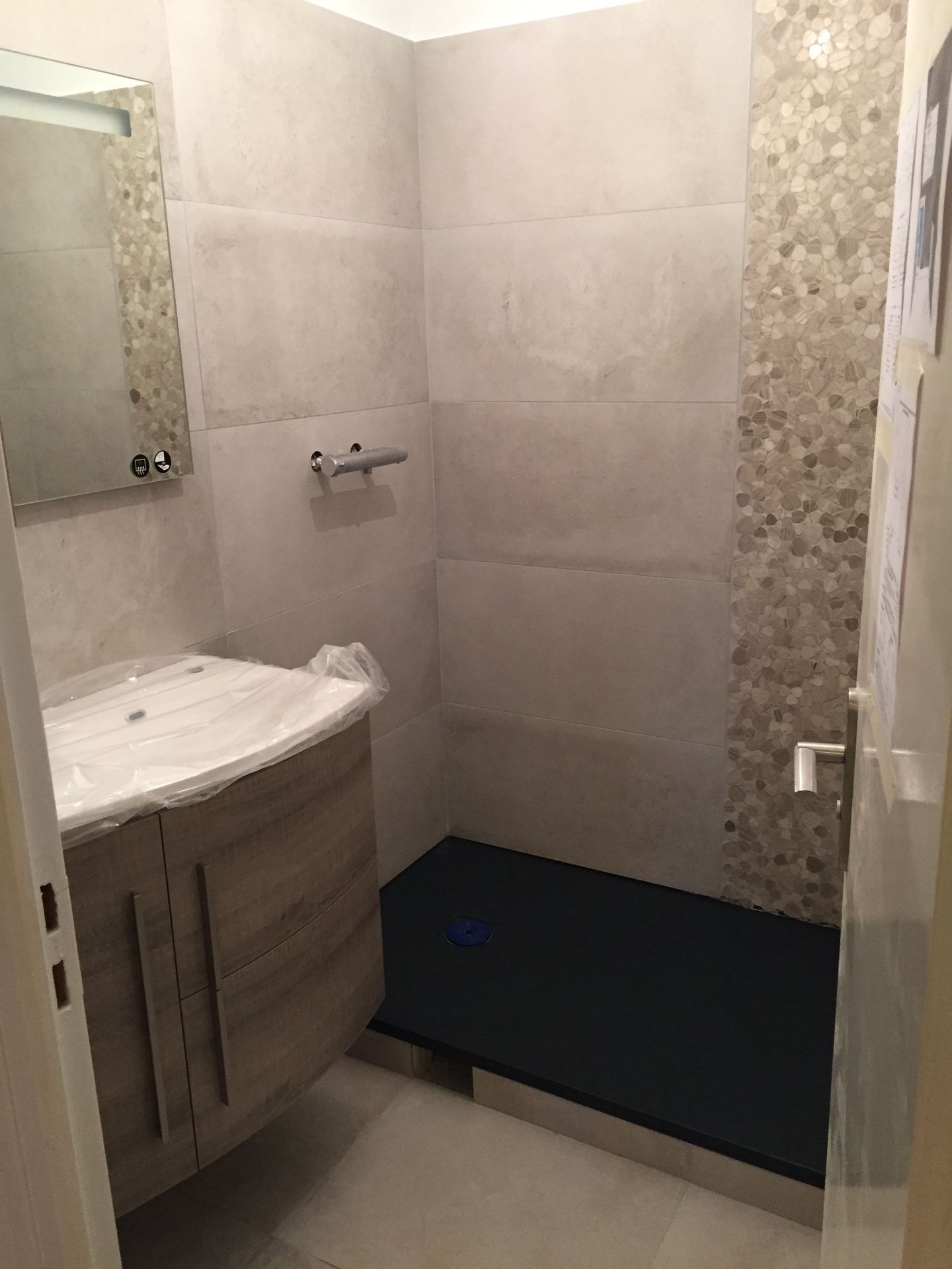 Salle de bains avec murs carrelés, douche