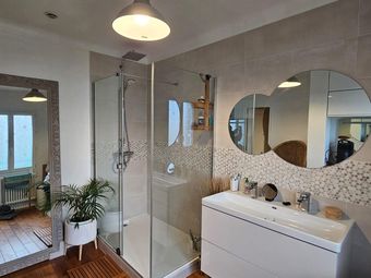Salle de bains moderne avec douche, meuble-lavabo et grand miroir