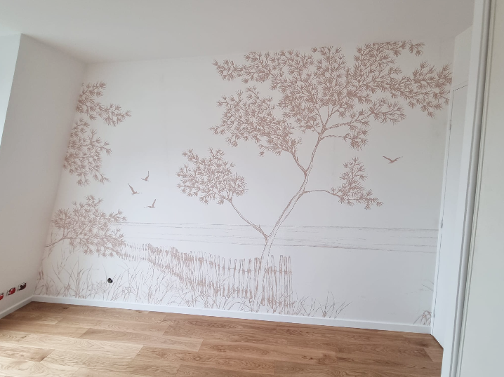 Une délicate fresque à l'encre brun clair représentant des arbres, une clôture et des oiseaux, peinte sur un mur blanc
