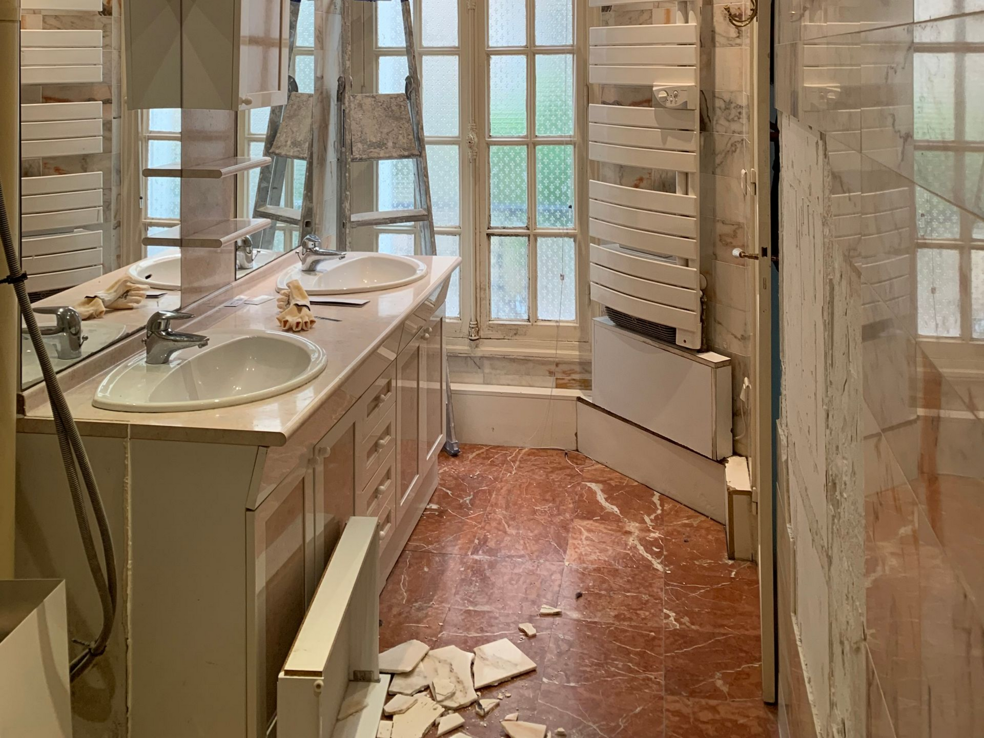 Salle de bains en cours de rénovation avec des débris sur le sol