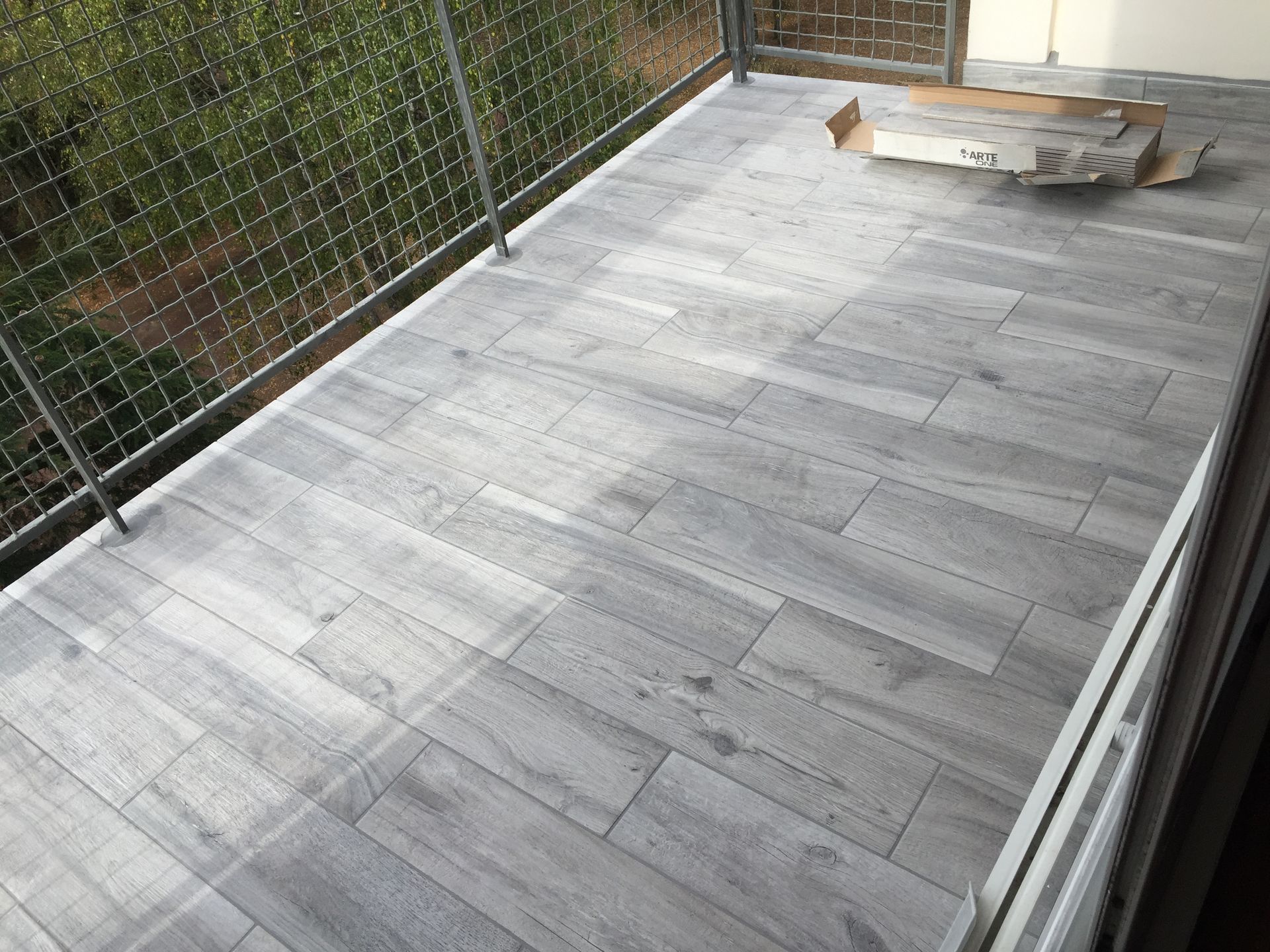 Balcon avec sol carrelé en carrelage gris clair imitation bois