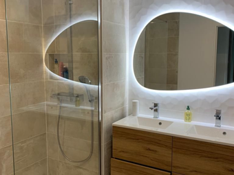 Salle de bains avec meuble-lavabo et miroir éclairé