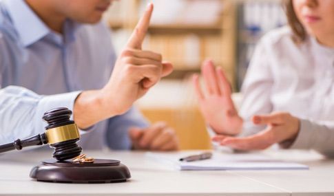 Un hombre y una mujer están sentados en una mesa con un mazo delante de ellos.
