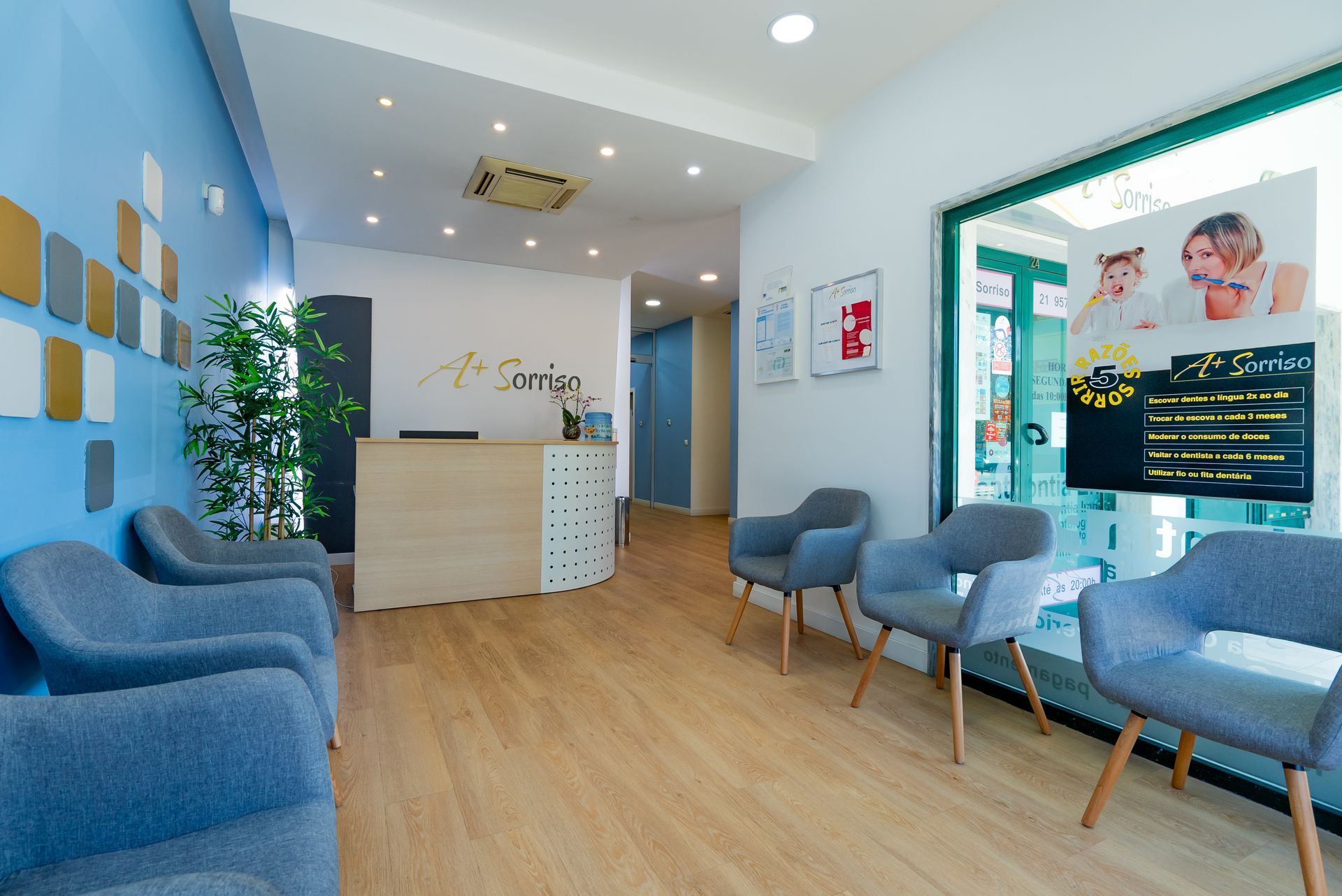 Exterior de uma clínica odontológica com placa em português. O prédio é verde-claro e cinza.