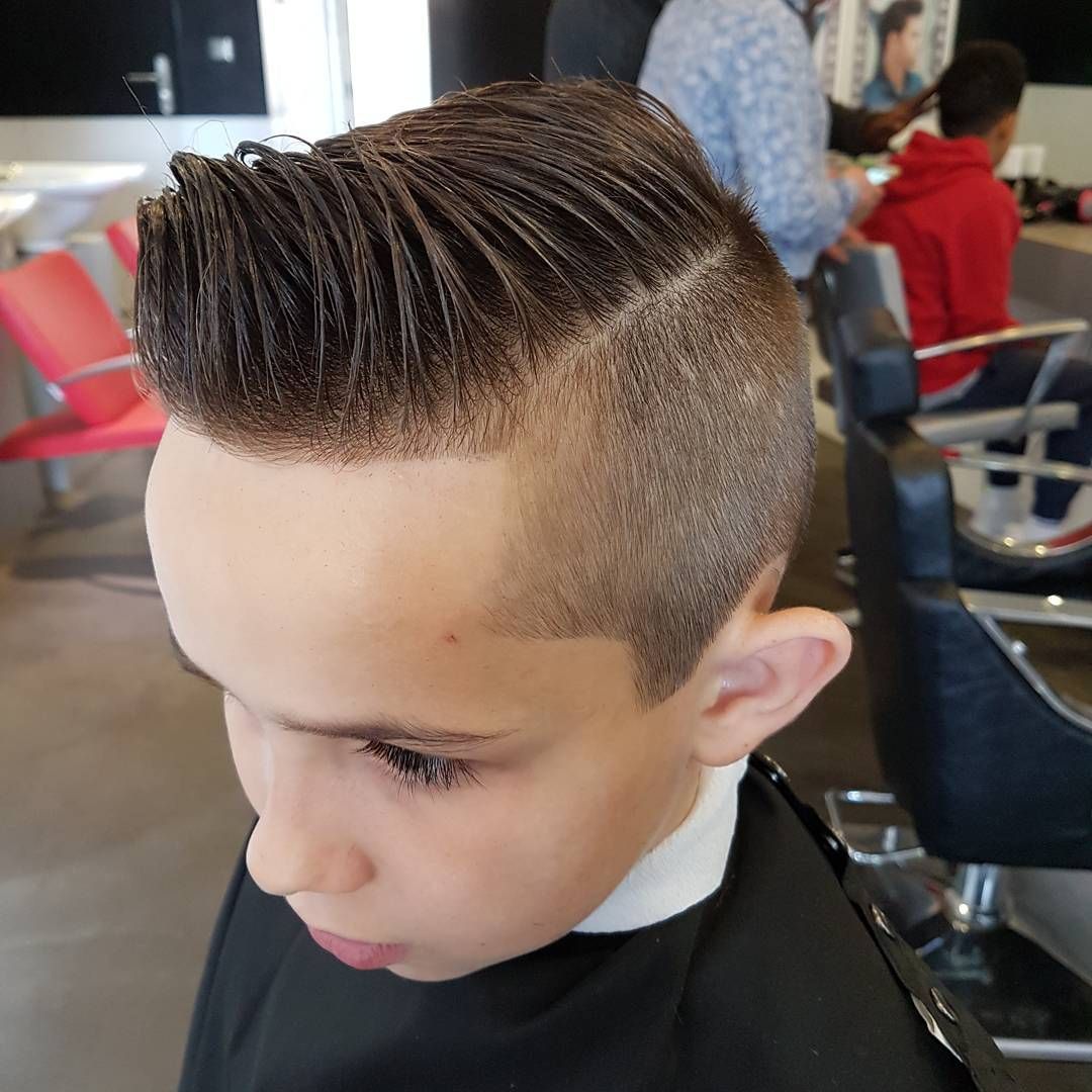 Un coiffeur coupe les cheveux d'un enfant