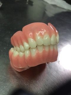 Uma mulher com um suéter vermelho está sorrindo e usando batom vermelho.