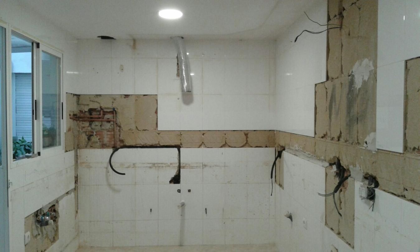 Renovación de cocina en proceso: paredes de azulejos blancos, infraestructura expuesta