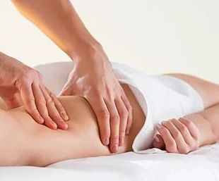 Una mujer está acostada en una cama recibiendo un masaje.