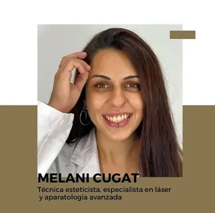 Una mujer con una bata de laboratorio sonríe y se toca el cabello.
