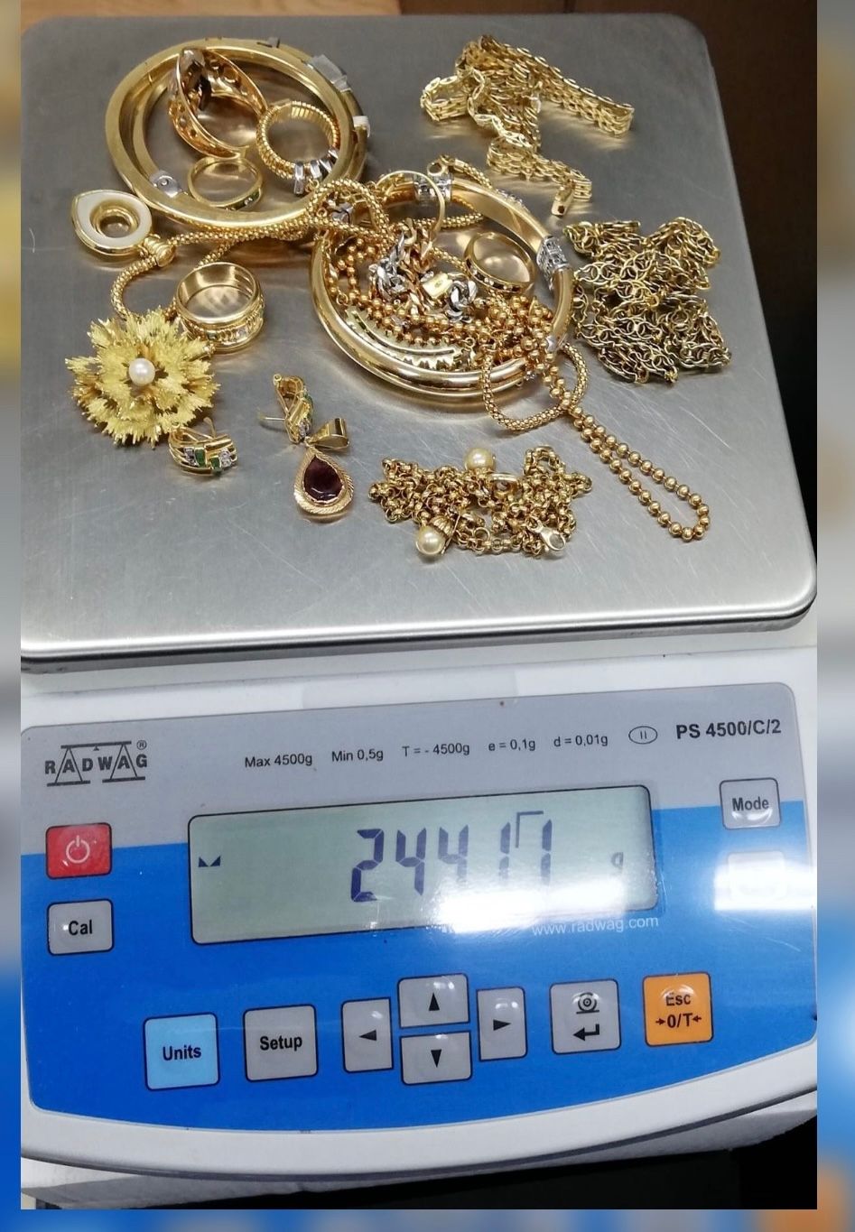 Joyas de oro en una báscula digital que marca 244,71 gramos.