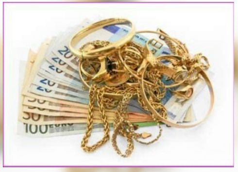 Cadenas y anillos de oro apilados sobre billetes de euro sobre un fondo blanco.