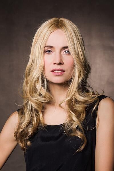 Die Frau trägt eine Perücke und ein schwarzes Kleid.