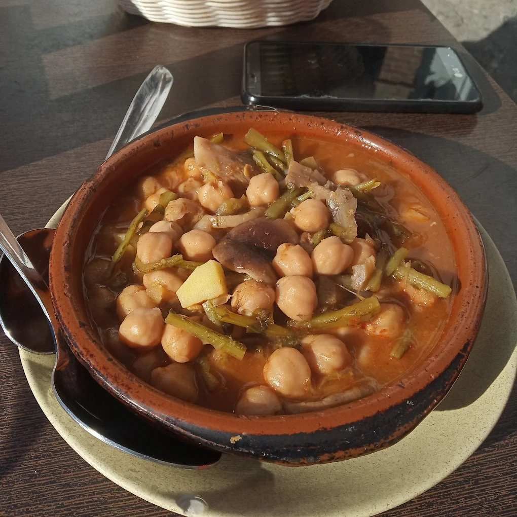 Camarones fritos en un plato blanco con un chorrito de salsa de naranja, rodaja de limón y rúcula.