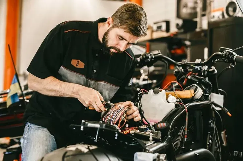 Un hombre está trabajando en una motocicleta en un garaje.