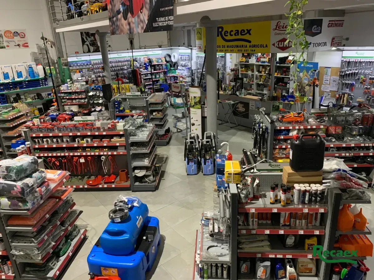 Un pasillo de una ferretería con estantes llenos de herramientas, suministros y una máquina limpiadora