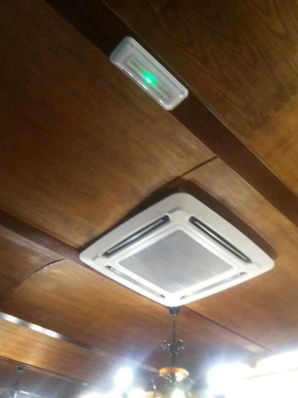 Un ventilador de techo con una luz verde encendida.