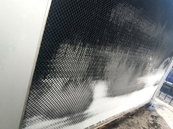 Una fotografía en blanco y negro de una valla de la que sale espuma.