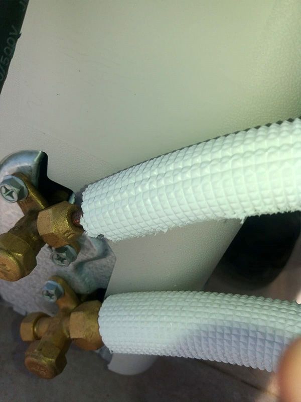 Un primer plano de una tubería blanca con accesorios de latón.