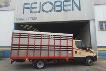 Un camión está estacionado frente a un edificio que dice fejoben