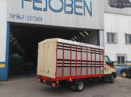 Un camión estacionado frente a un edificio que dice tejoben
