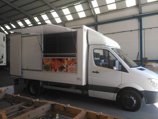 Un camión de comida blanco está estacionado en un almacén.